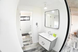 a white bathroom with a sink and a mirror at Depto. en Costanera frente al rio 2 a 4 personas in San Nicolás de los Arroyos +14 photos
