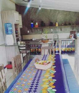 una cocina con una mesa con un bol de fruta. en Pousada Max House entre Praias de SFS en São Francisco do Sul