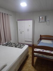 a small bedroom with two beds and a cabinet at Real Hospedagem in Manaus