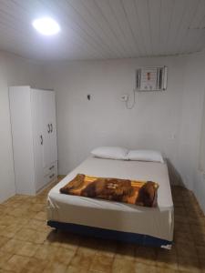 a bedroom with a bed in a white room at Real Hospedagem in Manaus