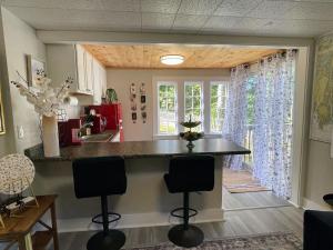 una cocina con una encimera con dos taburetes. en Edgecomb 1, en Edgecomb