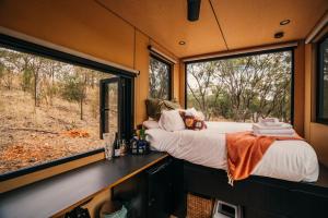 a bedroom with a bed and a large window at CABN Off Grid Cabins Barossa in Seppeltsfield