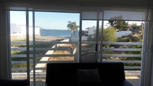 a room with a view of the ocean through a window at DEPARTAMENTO SOL Y MAR in San Carlos