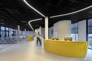 a large office with a yellow desk and chairs at Prize by Radisson, Munich Airport in Hallbergmoos