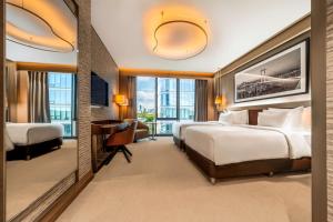 a hotel room with two beds and a desk at Radisson Collection Hotel, Vadistanbul in Istanbul