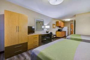 a hotel room with two beds and a desk with a computer at Studio 6 Lenexa - Overland Park in Lenexa