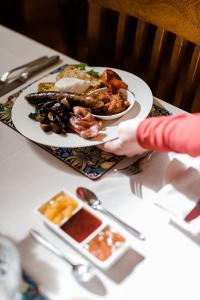 una persona sosteniendo un plato de comida en una mesa en Amberesque B&B, en Rutherglen
