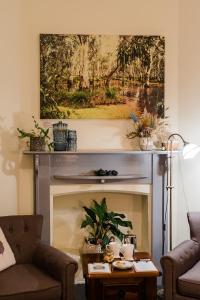 a living room with a fireplace with a painting above it at Amberesque B&B in Rutherglen