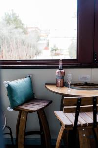 a table and chairs next to a window with a glass at Amberesque B&B in Rutherglen