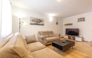 a living room with a couch and a tv at 4 Bedroom Cozy Home In Otok in Otok