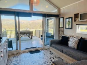 a living room with a couch and a view of a deck at Oak Tree View in Nantmel