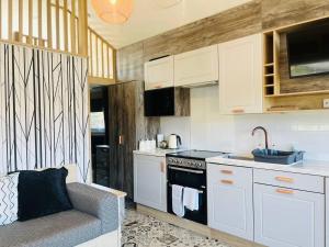 eine Küche mit weißen Schränken und einem Sofa in einem Zimmer in der Unterkunft Oak Tree View in Nantmel