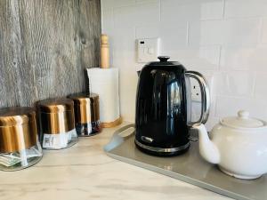 Kaffee und ein Wasserkocher auf der Theke in der Unterkunft Oak Tree View in Nantmel