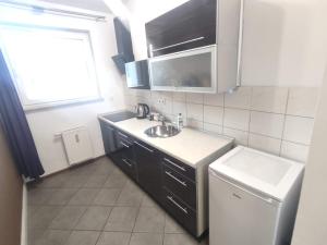 una pequeña cocina con fregadero y ventana en 2110 Zwycięstwa 5N - Tanie Pokoje w Apartamencie - samodzielne zameldowanie - self check in en Poznan