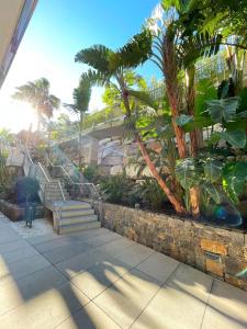 a set of stairs in a garden with palm trees at Apartamentos Novacala Benidorm in Cala de Finestrat