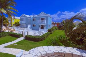 a large blue house with a lawn in front of it at Stunning Ocean View in Negril