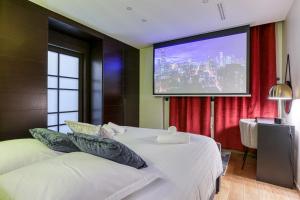 um quarto com 2 camas e um ecrã de projecção em Montaigne Executive Suite em Paris