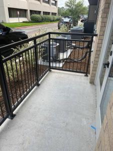 a black metal fence next to a walkway at The Lavish Experience 2Bed/2Bathroom W/Pool in Houston