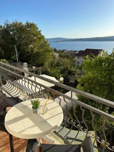 een balkon met tafels en stoelen en uitzicht op het water bij Apartments Badnje in Dramalj
