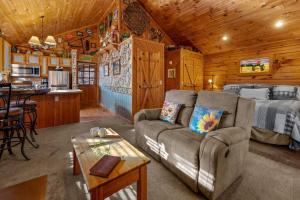 ein Wohnzimmer mit einem Sofa und einem Bett in einer Hütte in der Unterkunft The Mountain Farmer in Sevierville