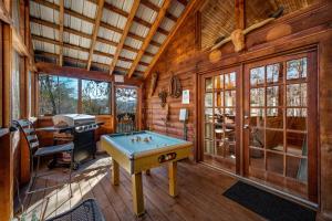 Habitación con mesa de billar en una cabaña de madera en The Mountain Farmer en Sevierville