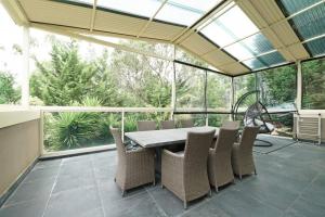 a conservatory with a table and chairs on a patio at Charming 6 BRM Villa in Melbourne Mullum Mullum Precinct in Doncaster East