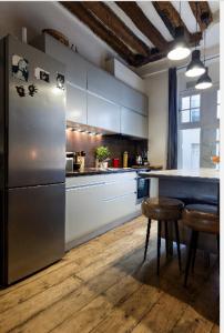 a kitchen with a refrigerator and a table and chairs at Appartement Panthéon in Paris