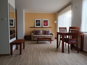 sala de estar con sofá, mesa y sillas en Hotel Boutique Confort Suites en Popayán