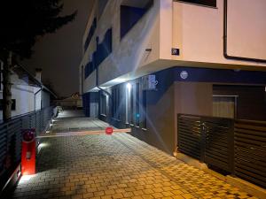 une rue vide la nuit avec un bâtiment dans l'établissement Grey Suites, à Zagreb