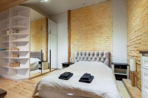 sypialnia z dużym łóżkiem i ceglaną ścianą w obiekcie Luxury apartment in Gedimino av. w Wilnie