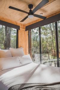CABN Off Grid Cabins Barossa في Seppeltsfield: غرفة نوم مع سرير ومروحة سقف