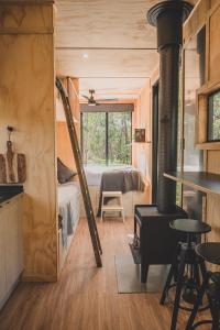a room with a bed and a room with a stove at CABN Off Grid Cabins Barossa in Seppeltsfield