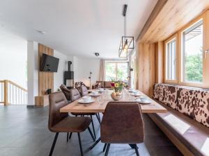 a dining room with a table and chairs and a couch at Schmittenblick 2 in Viehhofen