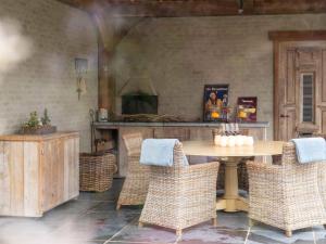 - une salle à manger avec une table et des chaises en osier dans l'établissement Tranquil villa in Vlaanderen with terrace, 
