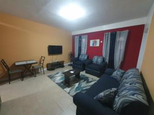 ein Wohnzimmer mit Sofa und Fernseher in der Unterkunft Lovely 2 Bedroom Apartment with shared pool in Roseau