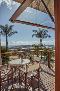 a patio with a table and chairs on a deck at Hillcrest Merimbula in Merimbula