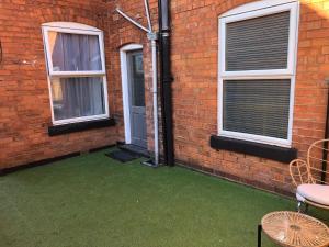 a brick building with a yard with green grass at SHM Stays Great for long term stays & Short Stays, 15 min drive to City Centre & Airport 2 min walk to Shops and Train Station in Birmingham