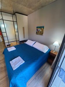 1 dormitorio con 1 cama azul en una habitación en Departamento - Salta Capital cg - Edificio Usina en Salta