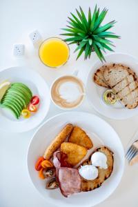 une table blanche avec deux assiettes de produits pour le petit-déjeuner dans l'établissement Club Wyndham Airlie Beach, à Airlie Beach