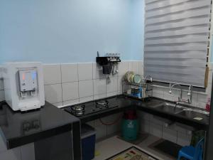 a kitchen with a sink and a counter top at MIZU Homestay Melaka in Melaka
