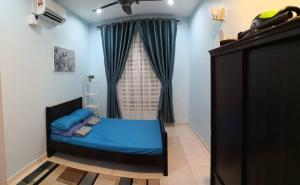 a small bedroom with a blue bed and a window at MIZU Homestay Melaka in Melaka
