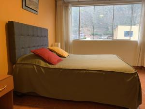 Cama en habitación con ventana grande en Hotel Acuario en Churín