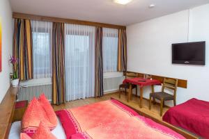 um quarto com uma cama, uma mesa e uma televisão em Gasthof Dangl em Wimpassing an der Pielach