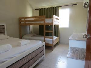 1 dormitorio con 2 literas y ventana en Bavaro Hostel, en Punta Cana