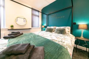 a bedroom with a large bed with a blue wall at Stunning house near Blackpool attractions in Blackpool