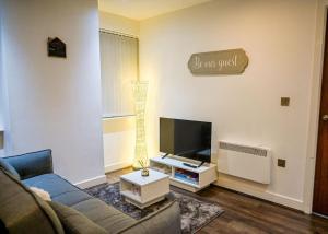 Luxury 2 bedroom apartment في برمنغهام: غرفة معيشة مع أريكة وتلفزيون بشاشة مسطحة