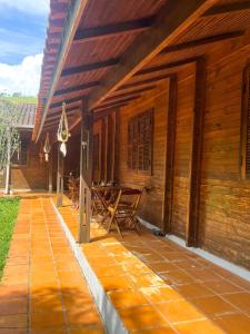 a porch of a wooden house with a table at Pousada Recanto das Hortênsias in Cunha