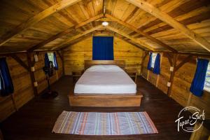1 dormitorio pequeño con 1 cama en una cabaña de madera en Tapas & Surf, en Petacaltepe