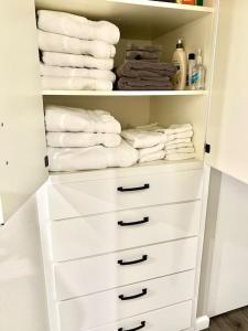 a closet with white towels and a rack of towels at Beautiful, well-stocked home - sleeps 7! in Yakima