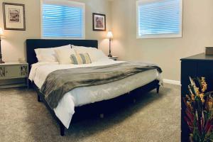 a bedroom with a large bed and two windows at Beautiful, well-stocked home - sleeps 7! in Yakima